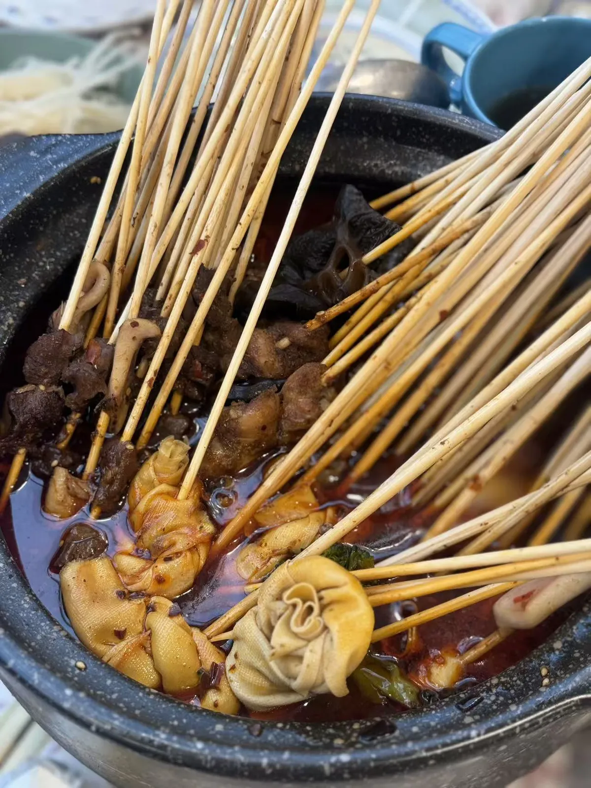 Hot pot with various ingredients on skewers